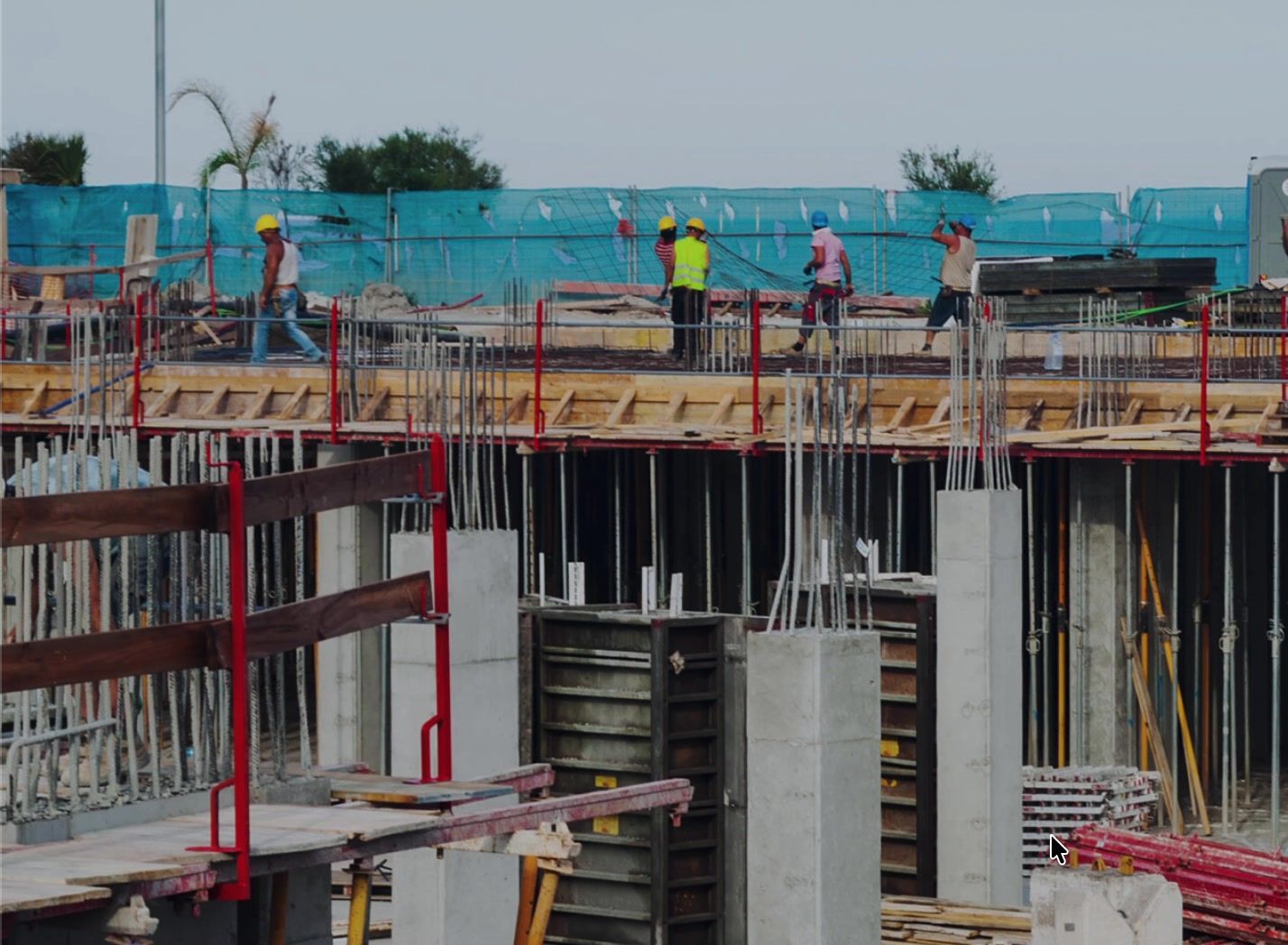 Obra en ejecución: columnas de hormigón, encofrado y obreros